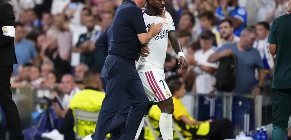 Coach guiding player off the pitch during match