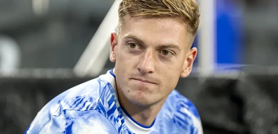 Player sitting on bench in blue jersey