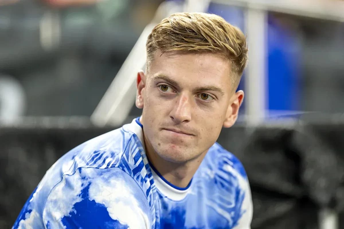 Player sitting on bench in blue jersey