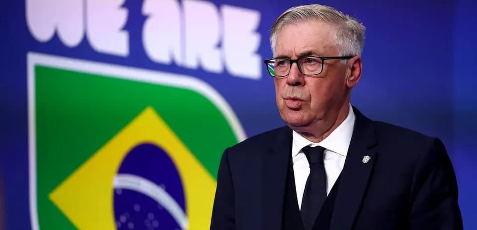 Coach speaking at podium with Brazil flag backdrop