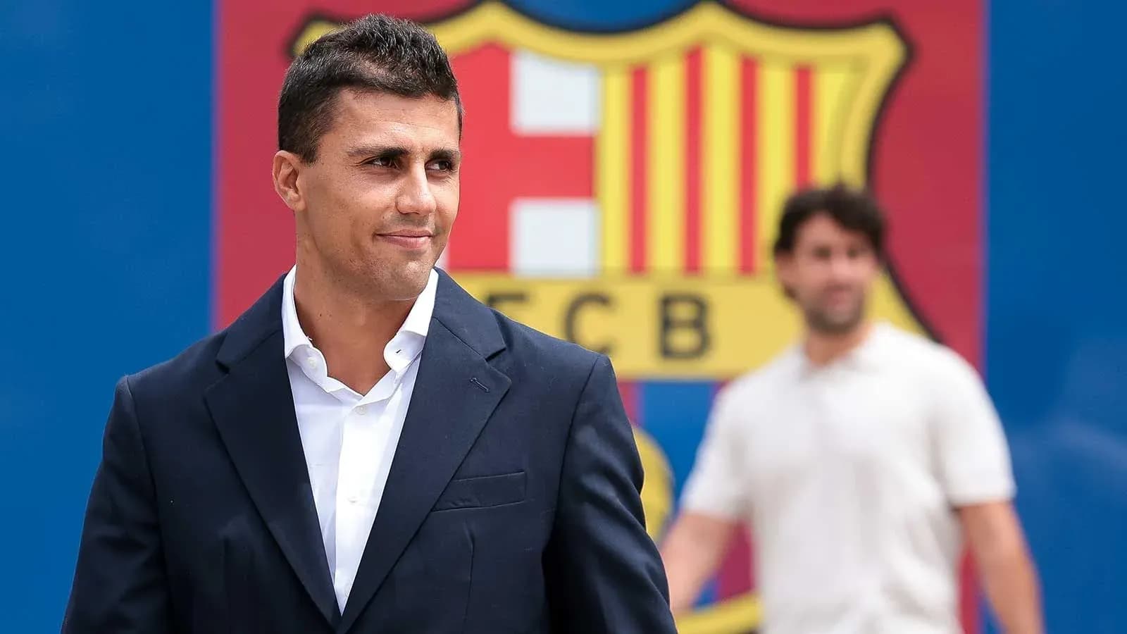 Man in suit with FC Barcelona logo background