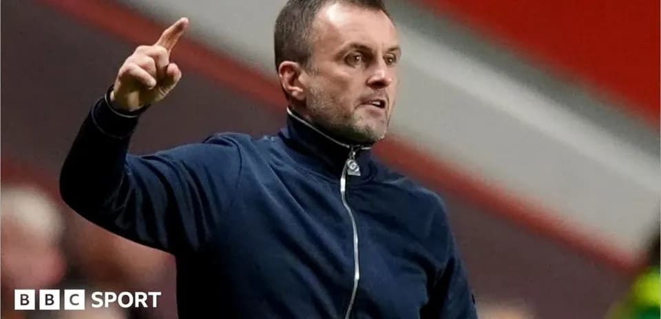 Manager gesturing during a match from the sidelines
