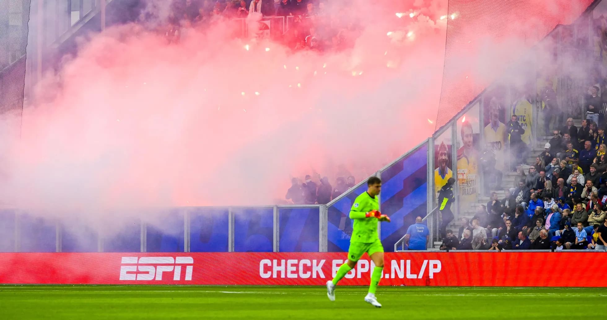 Goalkeeper walking past smoke during match celebration