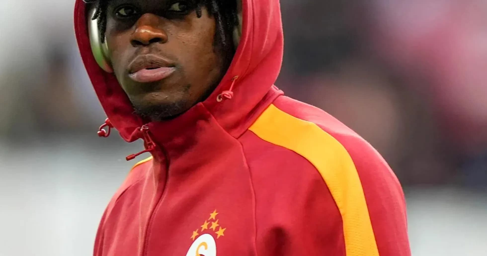Player in red Galatasaray tracksuit with hood