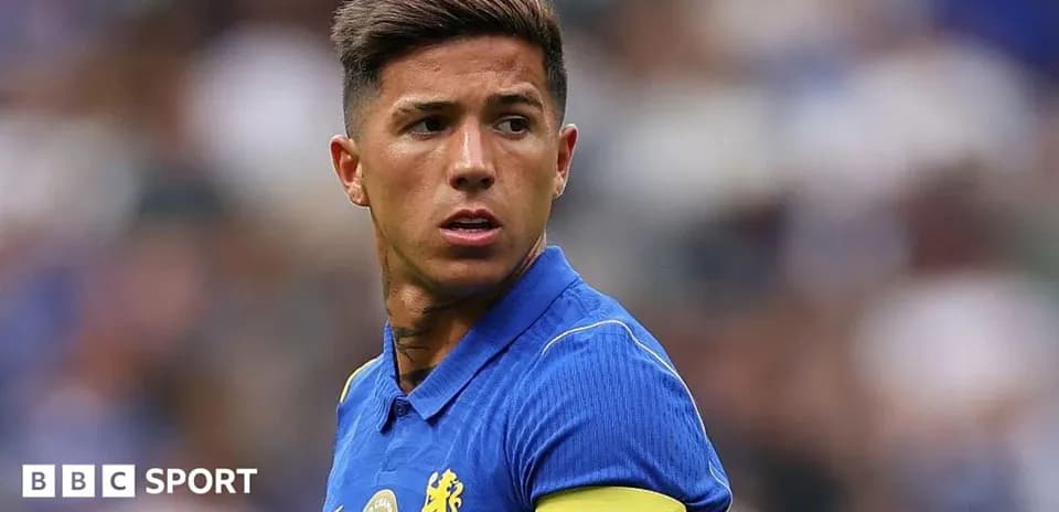 Player in blue jersey with captain armband on pitch