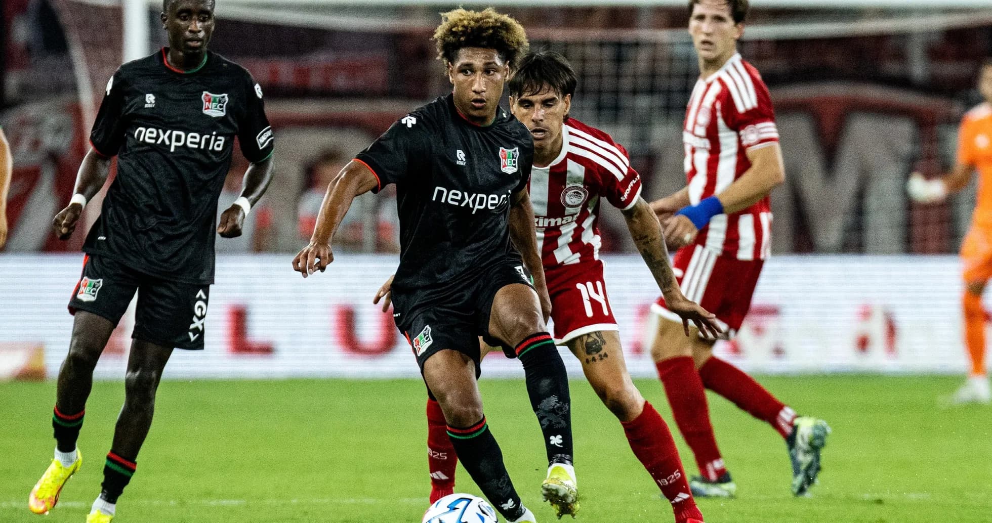 NEC Nijmegen player dribbling past Olympiakos opponent