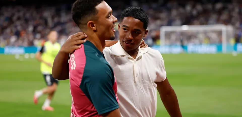 Two young men embracing on football pitch