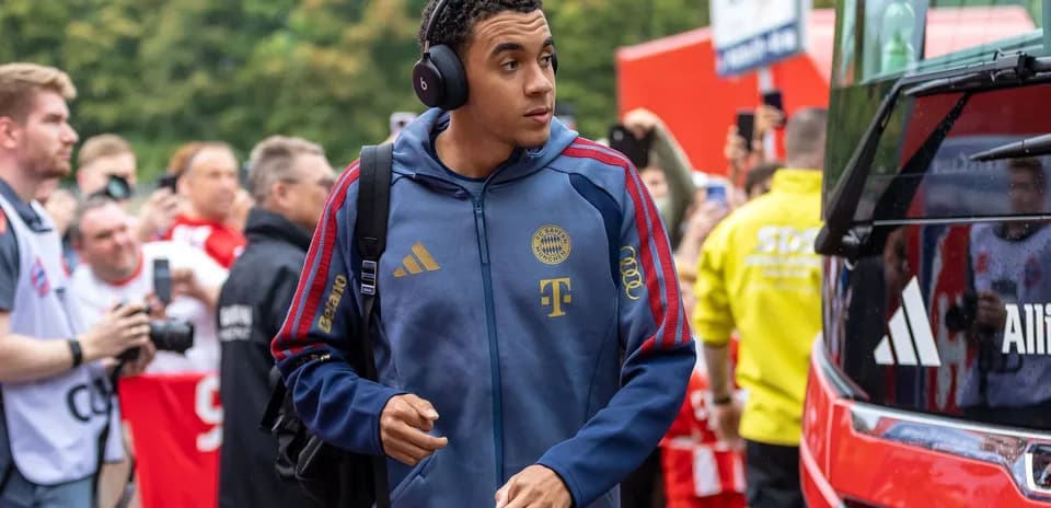 Player arriving at stadium wearing headphones and team gear