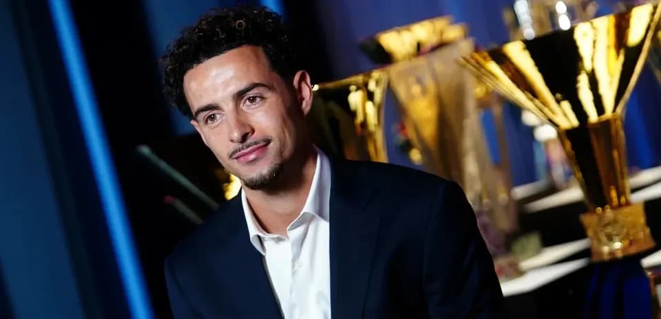 Player posing in front of trophies at event