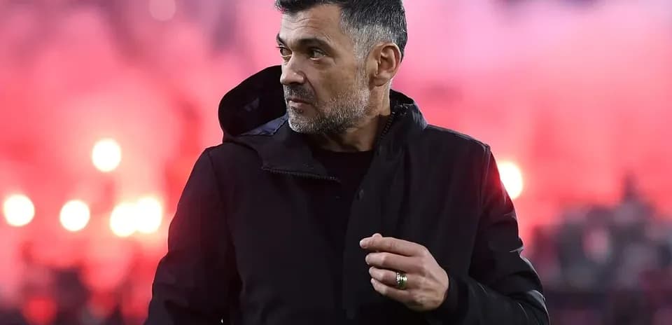 Coach observing match with smoke in background