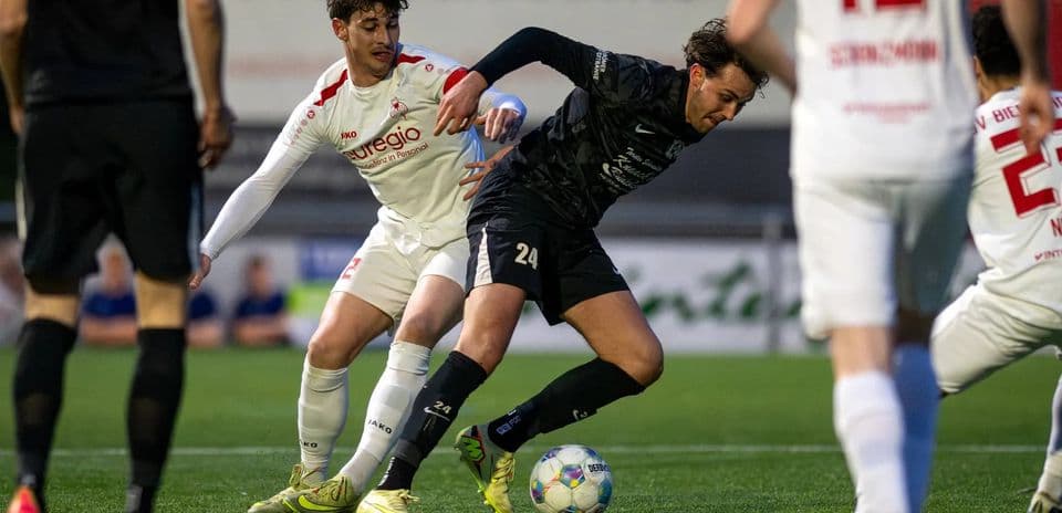 Two players battling for the ball in football match