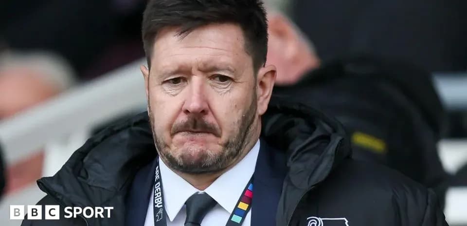 Manager in a coat on the sidelines during match