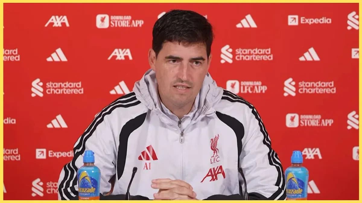 Manager speaking at press conference with Liverpool backdrop