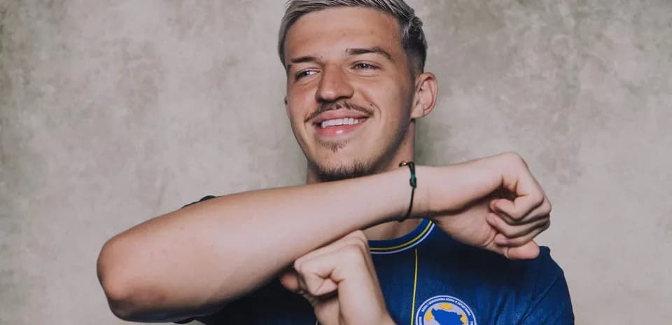 Player smiling and gesturing in team jersey