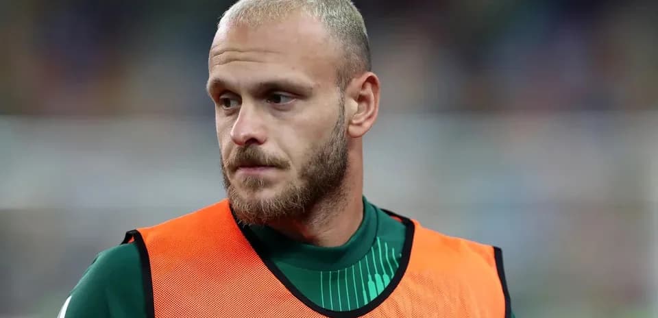 Player in training kit wearing an orange bib
