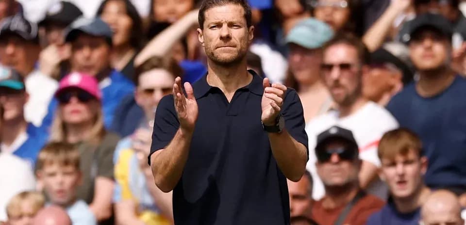 Coach applauding during a match with crowd behind