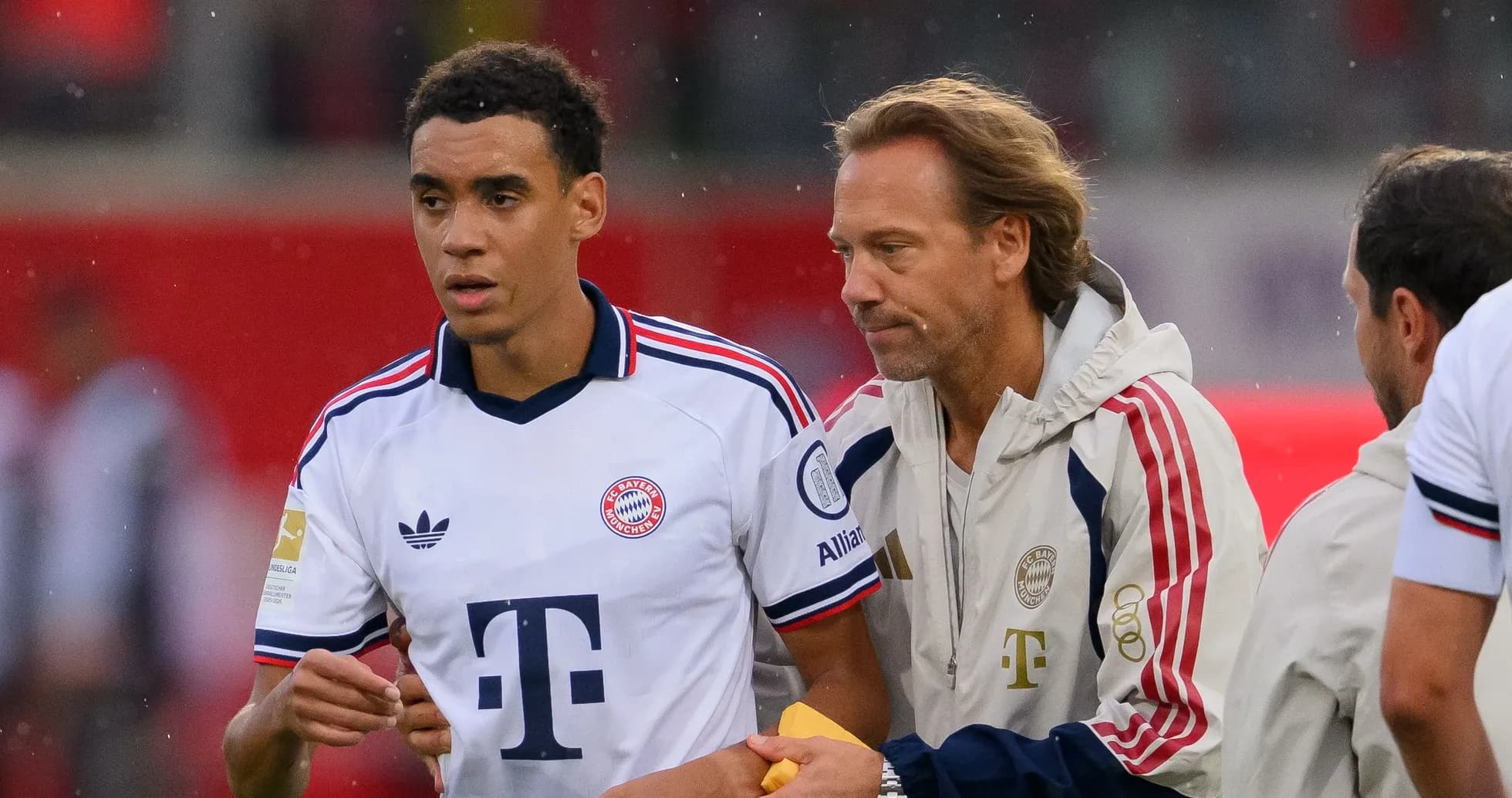 Bayern Munich player being guided by staff member