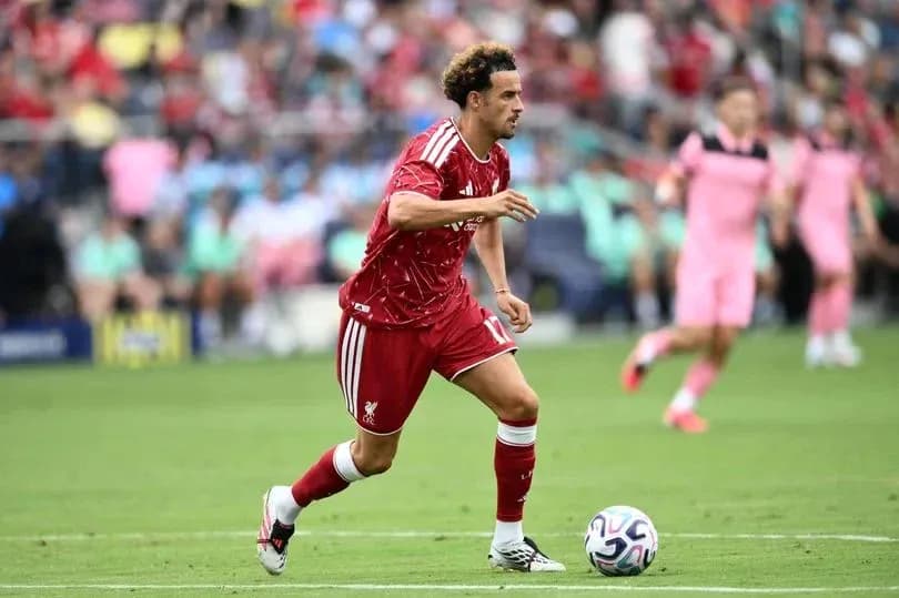 Player in red jersey running with ball during match