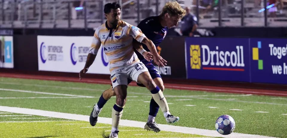 One Knoxville player dribbling past opponent