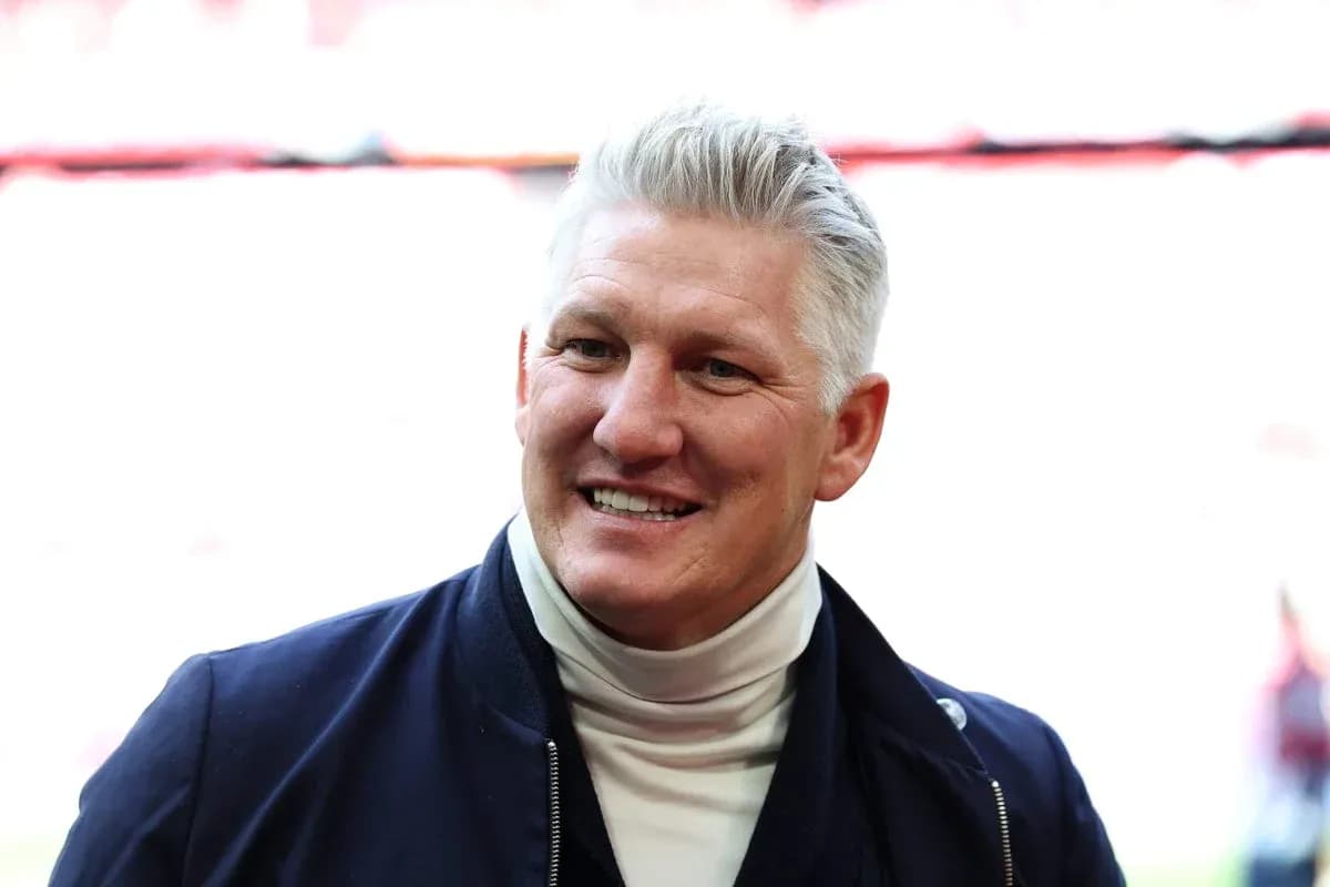 Man smiling in a jacket at stadium entrance