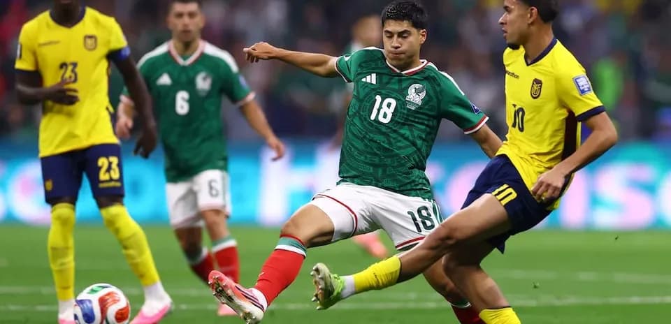 Mexico player tackling Ecuador opponent during match