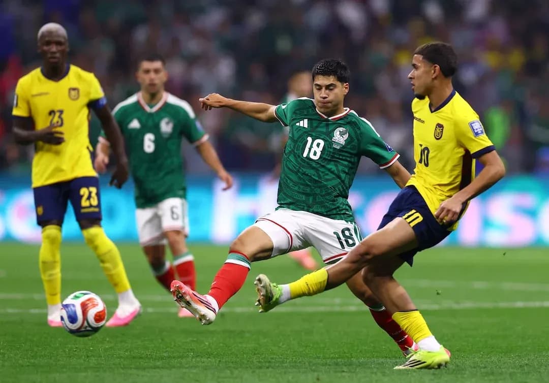 Mexico player tackling Ecuador opponent during match