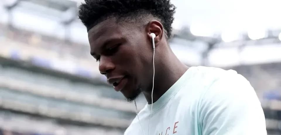 Player wearing earbuds on the field before match