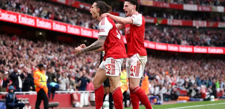 Two Arsenal players celebrating a goal on pitch