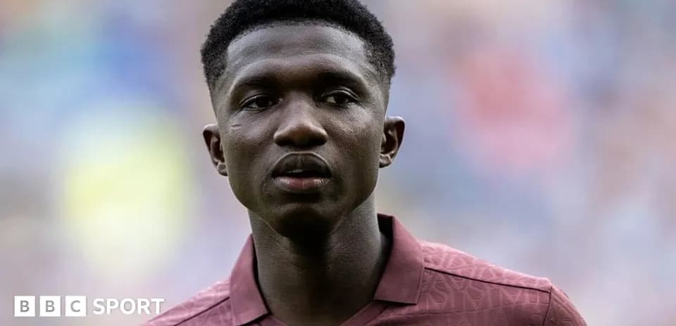 Player in maroon jersey during pre-match warm-up