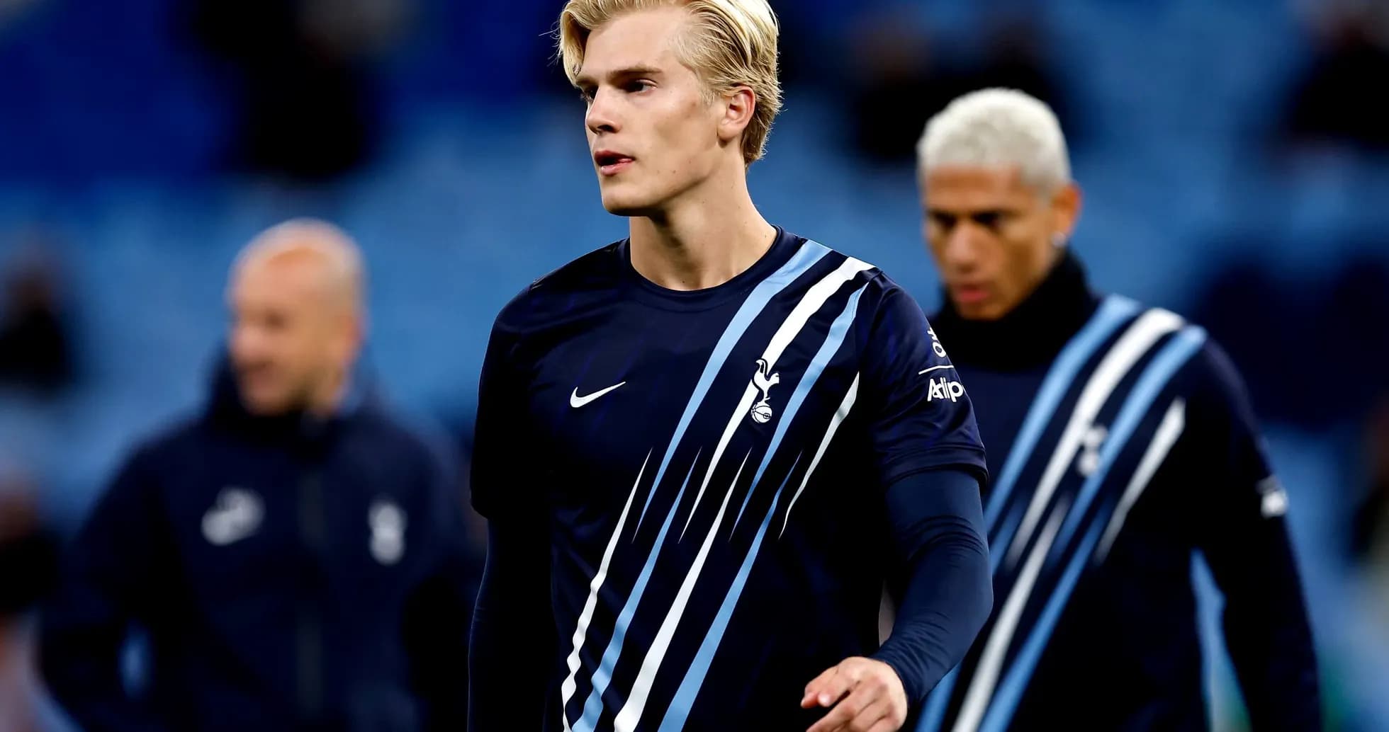 Player in Tottenham training kit walking on pitch