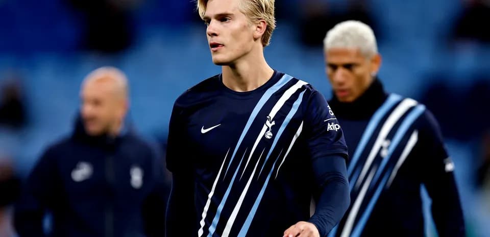 Player in Tottenham training kit walking on pitch