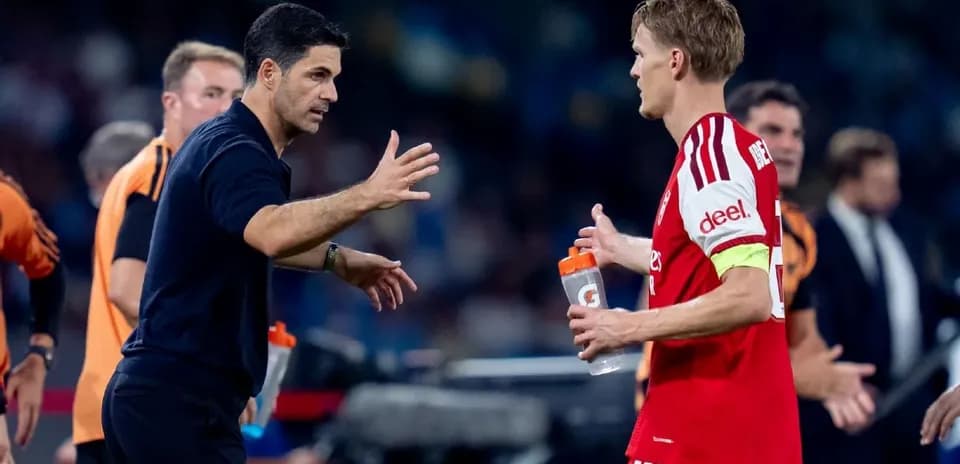 Coach discussing strategy with player on sidelines