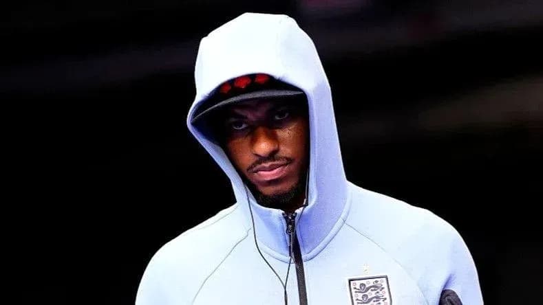 Player in hoodie walking towards the field