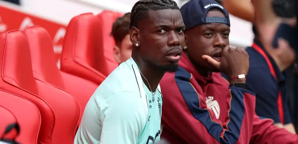 Two players sitting on red benches at stadium