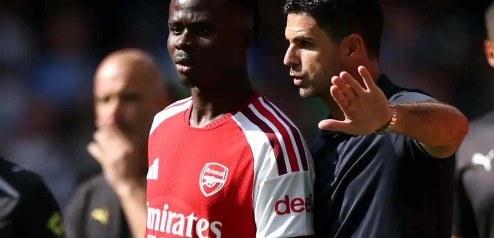 Arsenal coach discussing strategy with player during match