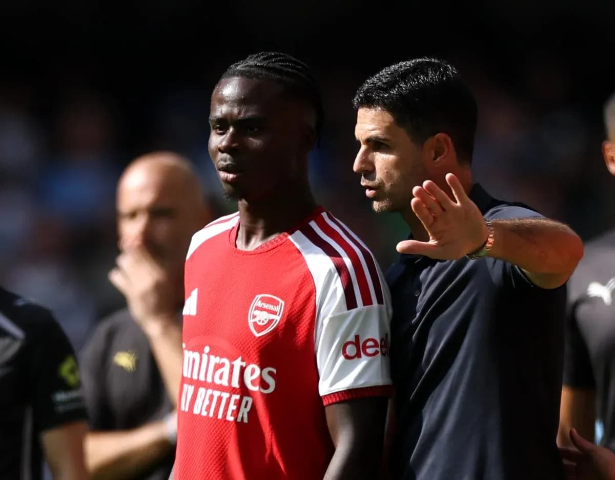 Arsenal coach discussing strategy with player during match