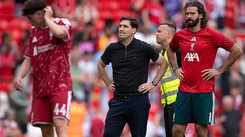 Liverpool players and staff on the pitch at Anfield