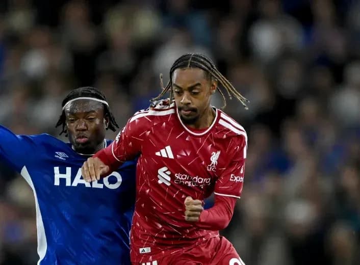 Liverpool player dribbling past opponent during match