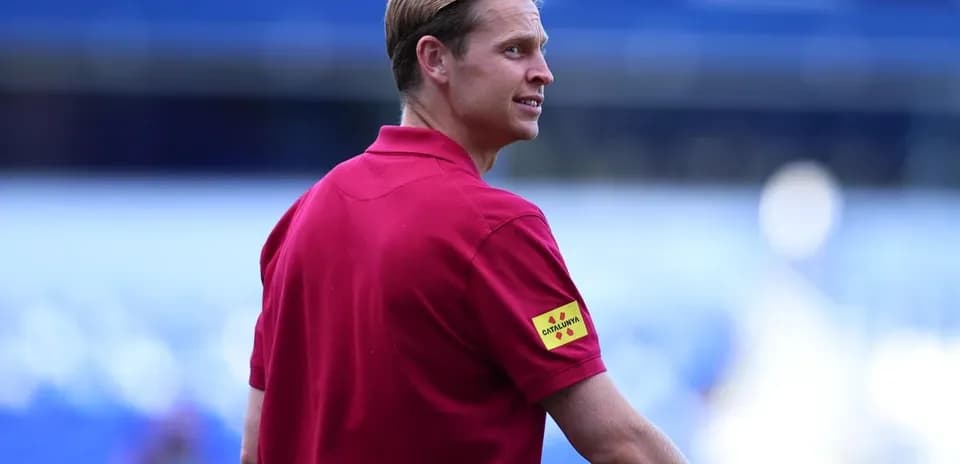 Official wearing red shirt at stadium sidelines