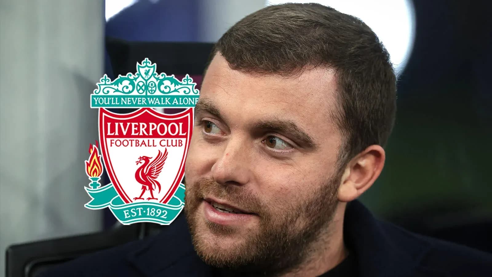 Man with beard beside Liverpool FC logo