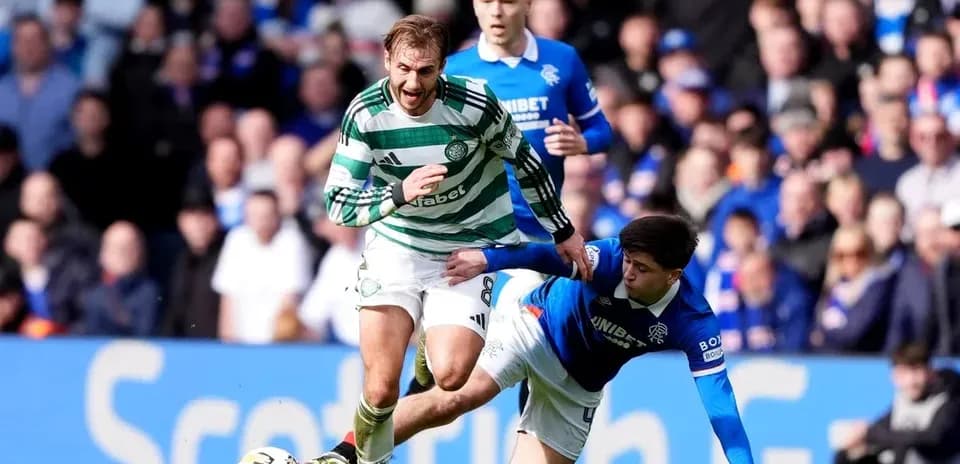 Celtic player evading tackle from Rangers player