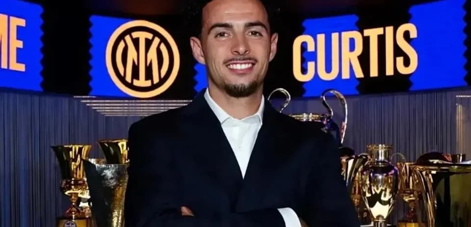 Man smiling in front of trophy display