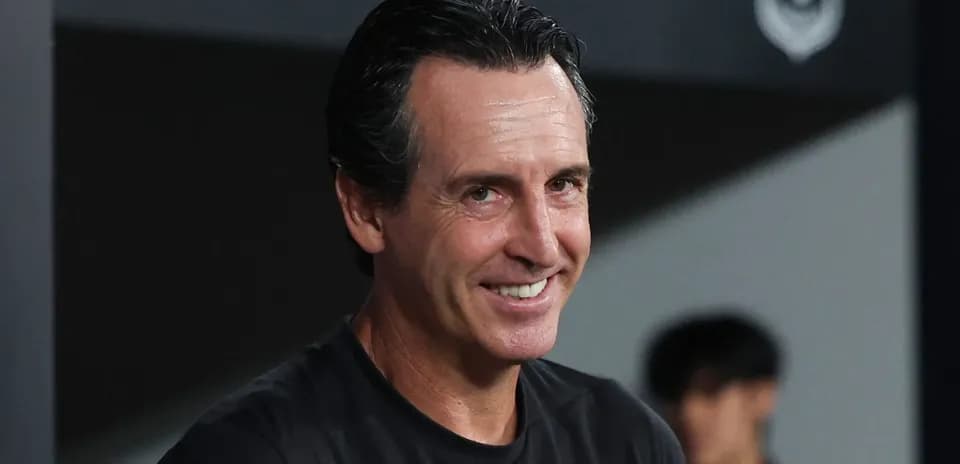 Coach smiling during a match in the dugout