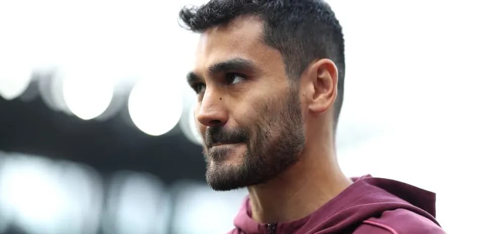 Player in maroon jacket during stadium appearance