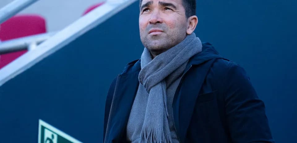 Man in a scarf looking up at stadium
