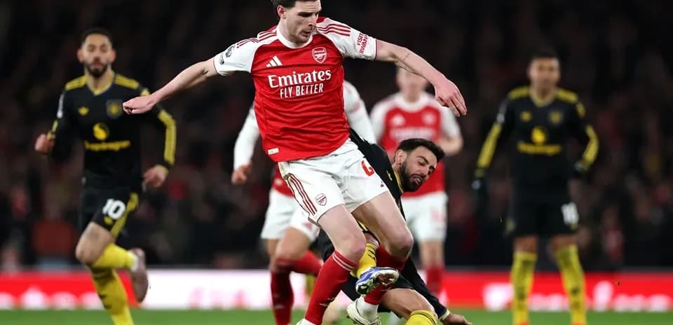 Player from Arsenal evading tackle during match