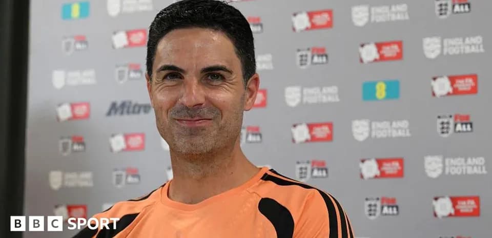 Coach smiling during press conference at backdrop
