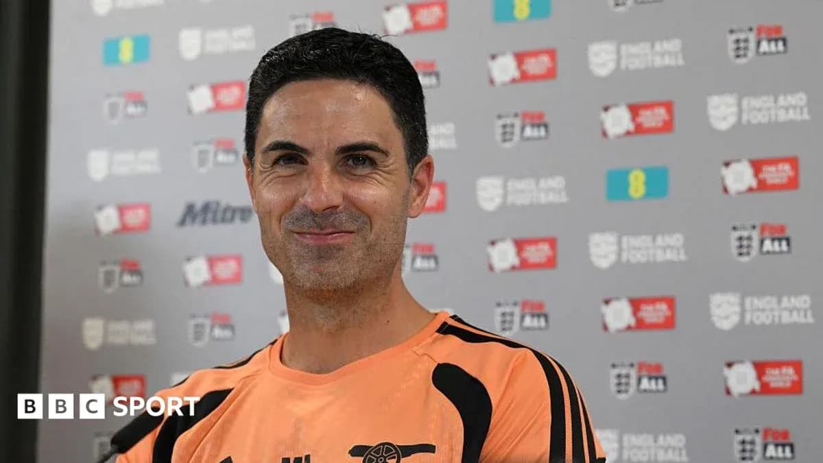 Coach smiling during press conference at backdrop
