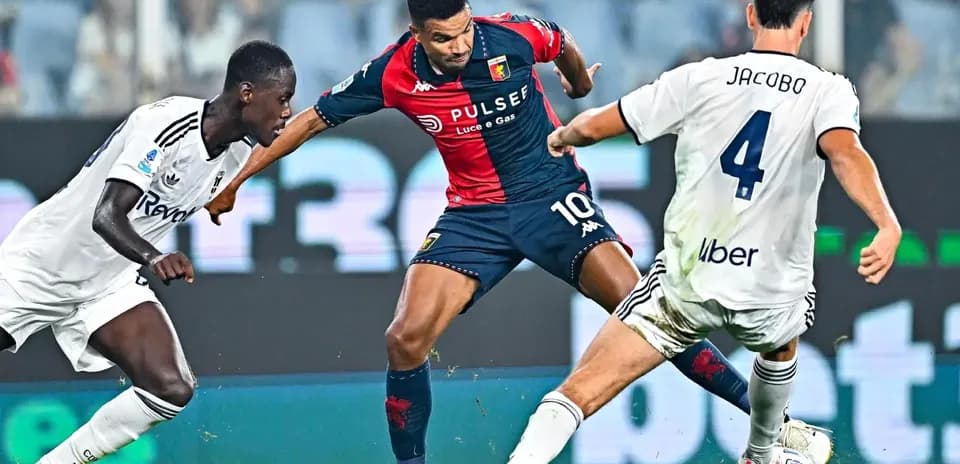 Genoa player dribbling past Como defenders