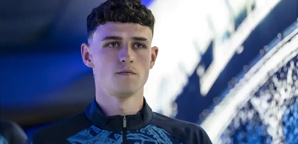 Player in Manchester City training gear standing indoors